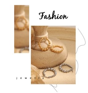 Detail of beaded hoop earrings with mixed polished and frosted metal textures