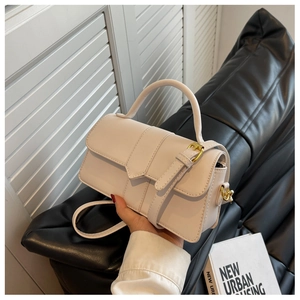 Close-up of white PU leather crossbody bag featuring gold buckle and strap detail