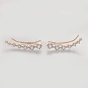 Close-up of rose gold curved ear climbers with multiple sparkling white cubic zirconia
