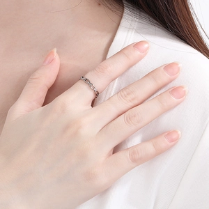 Detail of a minimalist silver chain ring worn on a finger for a modern unisex look