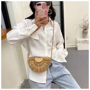 Woven bamboo handbag with wooden bead strap shown on model for summer beach vacation style
