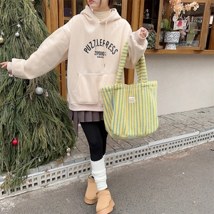 Sac fourre-tout en peluche à pois assorti à un sweat beige et une tenue hivernale