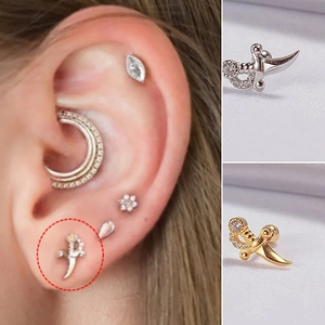 Detailed view of silver and gold sword stud earrings featuring cubic zirconia stones