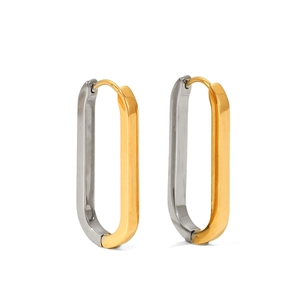 Macro detail of oval geometric earrings featuring a two-tone gold and silver polished finish