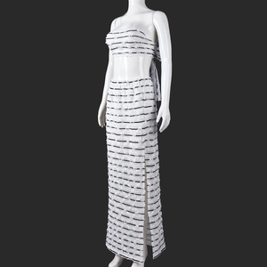 Detail of white striped knit set featuring a cropped tube top and side slit maxi skirt