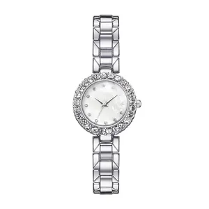 Macro detail of silver quartz watch featuring a crystal-set bezel and metallic link strap