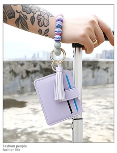 Close-up of a purple silicone beaded wristlet with a PU leather card holder and tassel