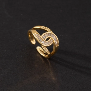 Detail of adjustable gold ring with twisted design and rectangular zircon stones