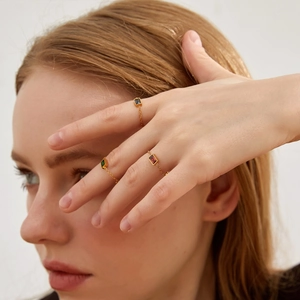 Three dainty adjustable chain rings with black, green, and red gems in 18K gold plating