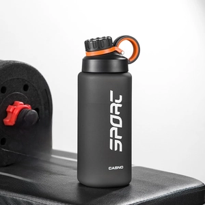 Close-up of matte black 800ml sports water bottle with tea infuser in a gym setting