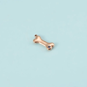 Detailed view of rose gold dog bone pendant with purple zircon and hanging loop