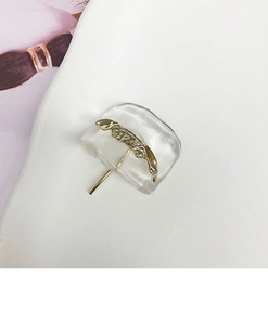 Macro detail of golden textured metal bar and transparent resin base hair clip