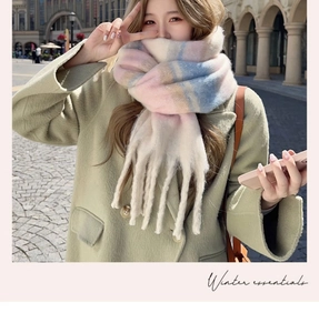 Close-up of pink and blue checkered plush scarf with soft fringe in natural outdoor light