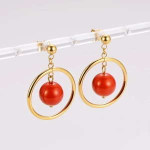 Vintage stainless steel gold hoop earrings with red bead pendant in professional studio lighting