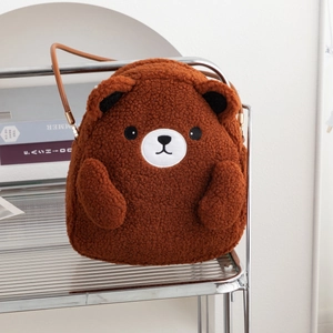 Detail of plush brown bear crossbody bag featuring soft sherpa texture and leather strap