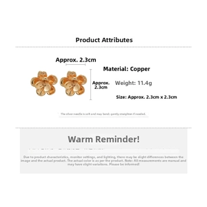 Detail view of gold floral stud earrings showing 2.3cm size and copper material specs