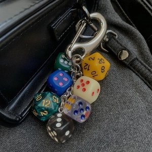 Multi-colored resin polyhedral dice keychain with alloy hook on black bag accessory