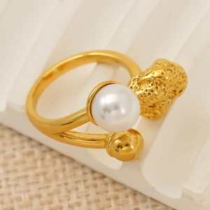 Gold open ring featuring a large white pearl and irregular lava texture detail