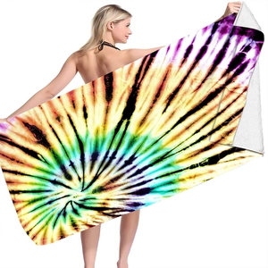 Detail of microfiber beach towel with vibrant spiral tie-dye pattern and soft texture