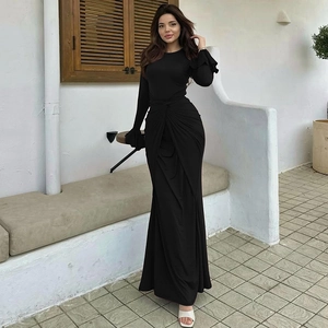 Détail de robe longue noire élégante avec nœud à la taille et poignets à volants