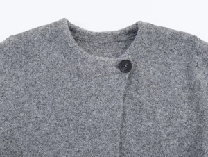 Détail d'un manteau gris en laine avec col rond et bouton noir de haute qualité