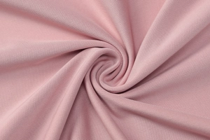 Close-up of pink ribbed knit fabric texture with spiral drape detail on a summer dress