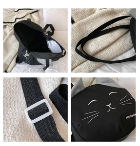 Detail view of black cat canvas bag showing strap, buckle and embroidered cat face