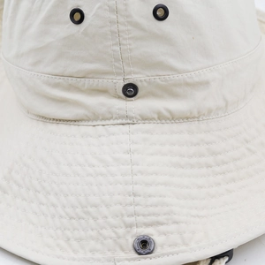 Macro detail of breathable metal eyelets and reinforced stitching on beige sun hat