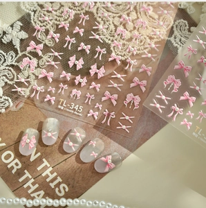 Detail of 3D pink bow nail art stickers with pearls and ribbon on delicate lace background