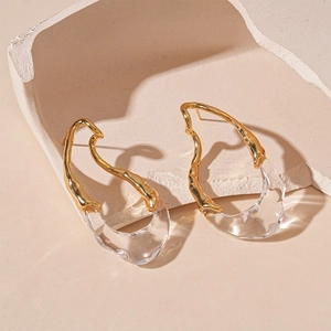 Abstract teardrop earrings in gold-plated metal and clear resin on geometric props