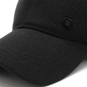 Detail of winter baseball cap showing black twill texture and matte square metal buckle