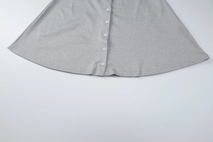 Detailed close-up of white buttons on a soft grey knit summer dress with smooth fabric texture