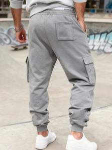 Detail of light grey cargo joggers with side pockets and tapered cuffs from back view