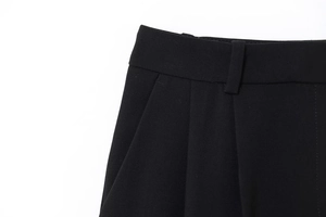 Détail de la taille d'un pantalon noir avec passants de ceinture et bords de poches