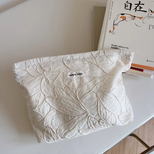 Detail of leaf pattern embroidery on beige canvas makeup bag with Simple Wish label