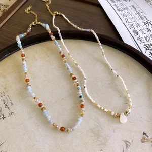 Detailed view of beaded necklaces with gemstones and teardrop pendant on retro tray