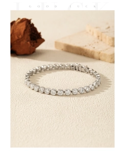 Detailweergave van de VVS1 moissanite tennisarmband met zilveren zettingen op steenvlak
