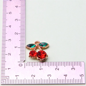 Size measurement of a red cherry fruit pendant with green crystals on a gold base