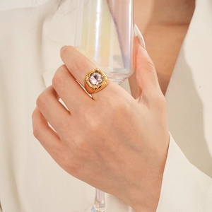 Primo piano di un anello dorato vintage con zircone rosa indossato da una modella