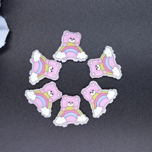 Detailed view of six resin pink bear and rainbow charms for DIY phone case crafts