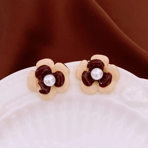 Detailed macro view of double-layer flower stud earrings with beige petals and pearl