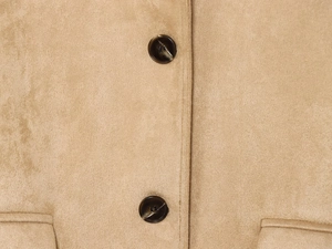 Detail shot of camel faux suede jacket featuring dark marble buttons and soft texture