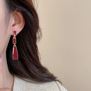 Detail view of vintage long geometric drop earrings in burgundy enamel and gold trim