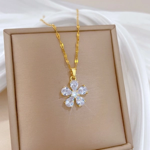 Macro detail of gold flower pendant featuring five pear-cut sparkling zircon stones