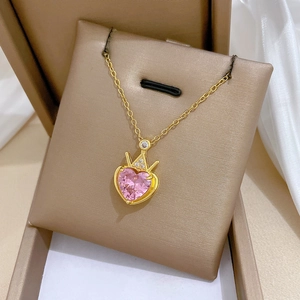 Luxurious gold crown heart necklace with pink gemstone in a beige gift box display