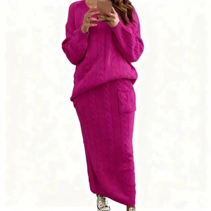 Détail d'un ensemble en maille rose rouge avec pull torsadé et jupe longue ajustée