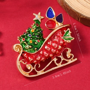 Close-up of Christmas sleigh brooch with red enamel and dimensions 3.4cm by 3.8cm