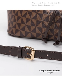 Detail of adjustable dark brown leather strap with golden metal buckle on bucket bag