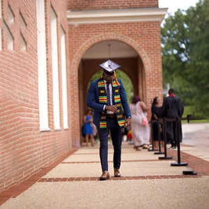 Macro shot of Kente style graduation stole with Class of 2022 text on black male graduate