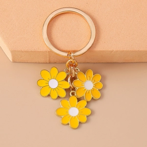 Close-up of golden keychain featuring yellow peach blossom pendants on a beige background